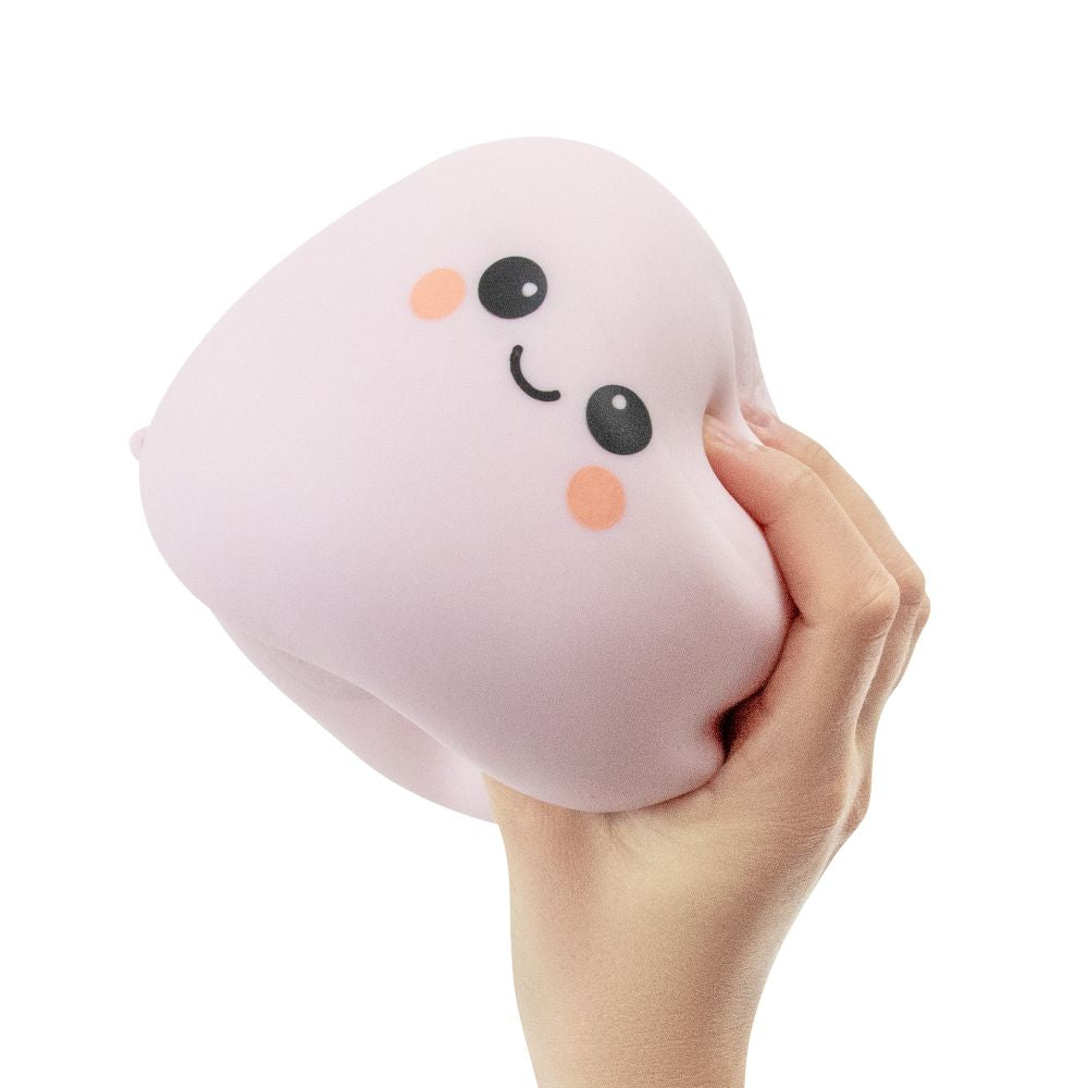 Hand squeezing the soft blush Big Squij Marshmallow squishy toy to show its texture
