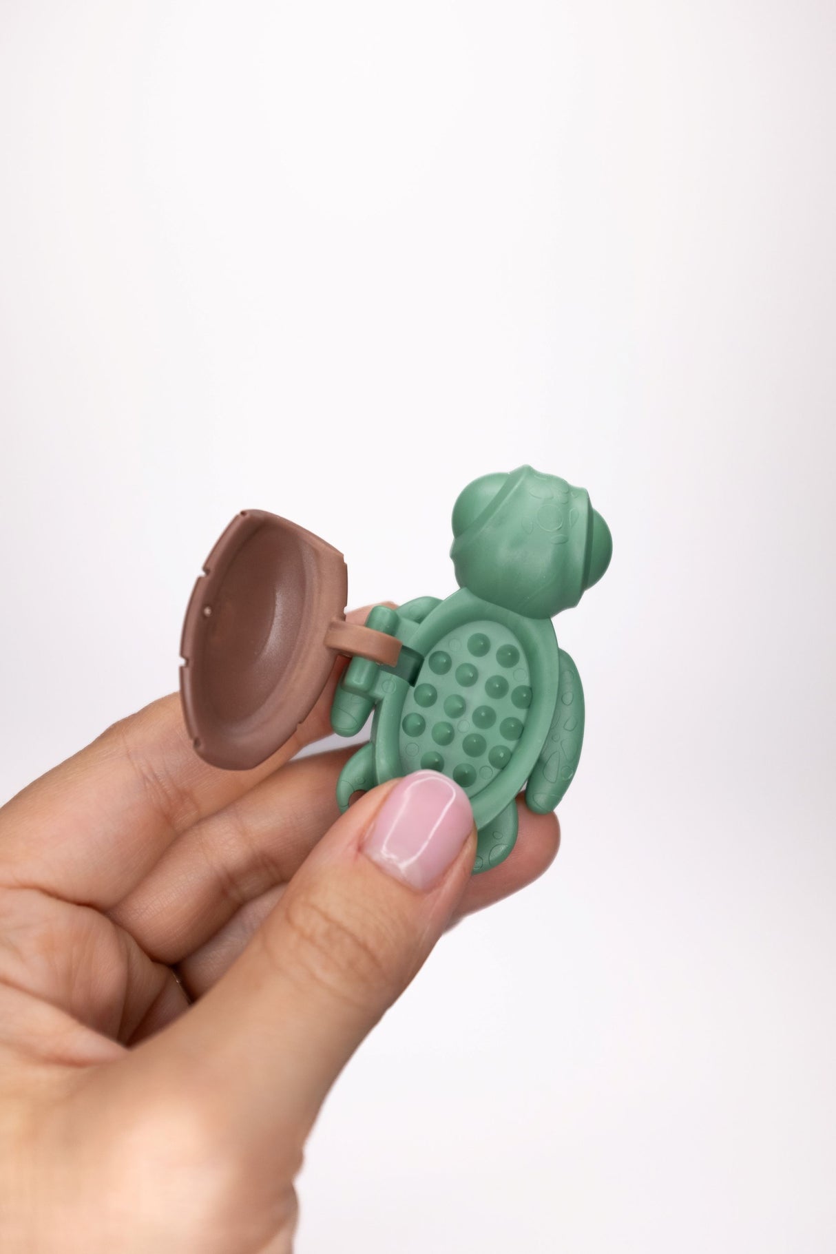 Sage green Calm Buddi Turtle held open, spiky inner shell sensory fidget