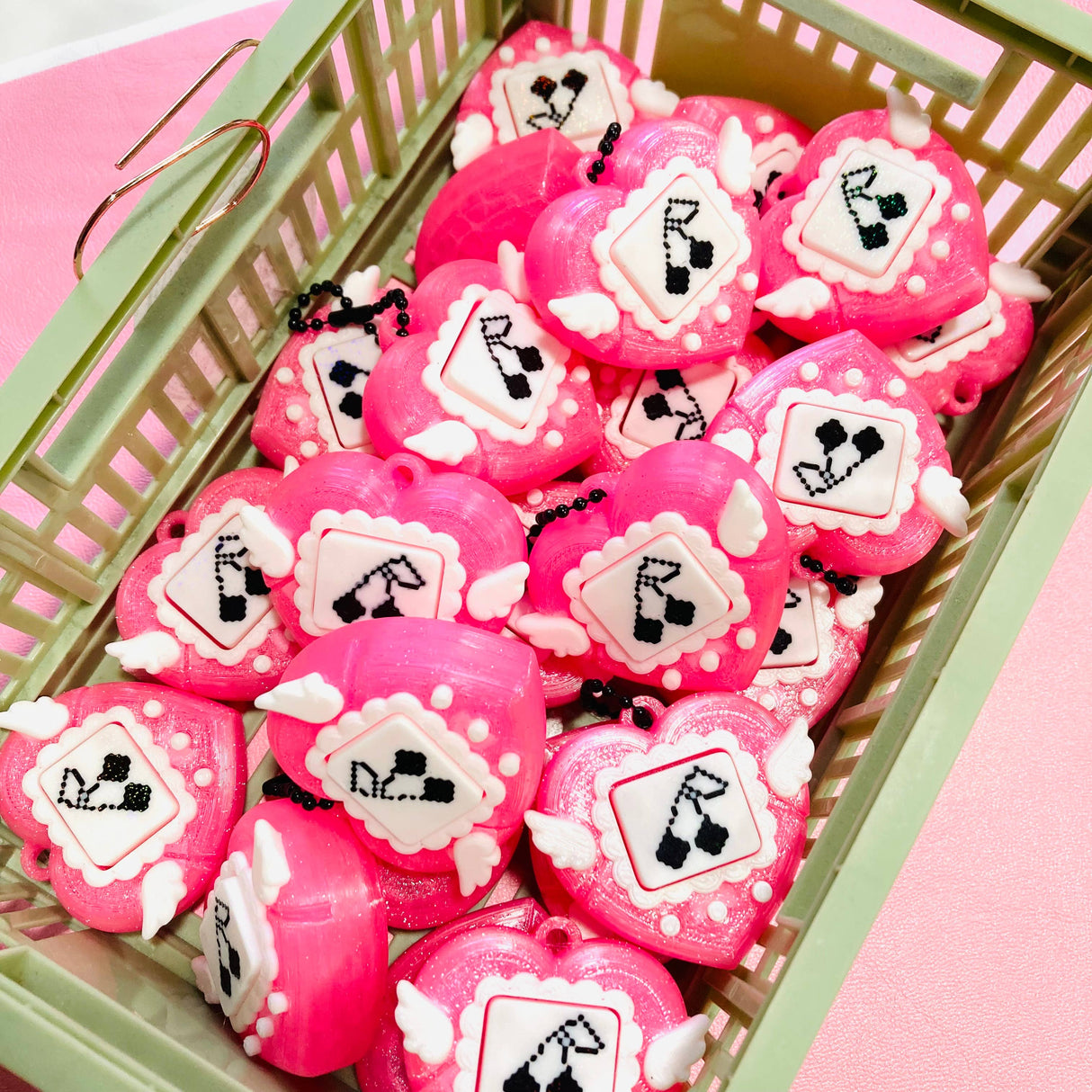 Collection of pink heart clicker fidget keychains displayed in a small green basket