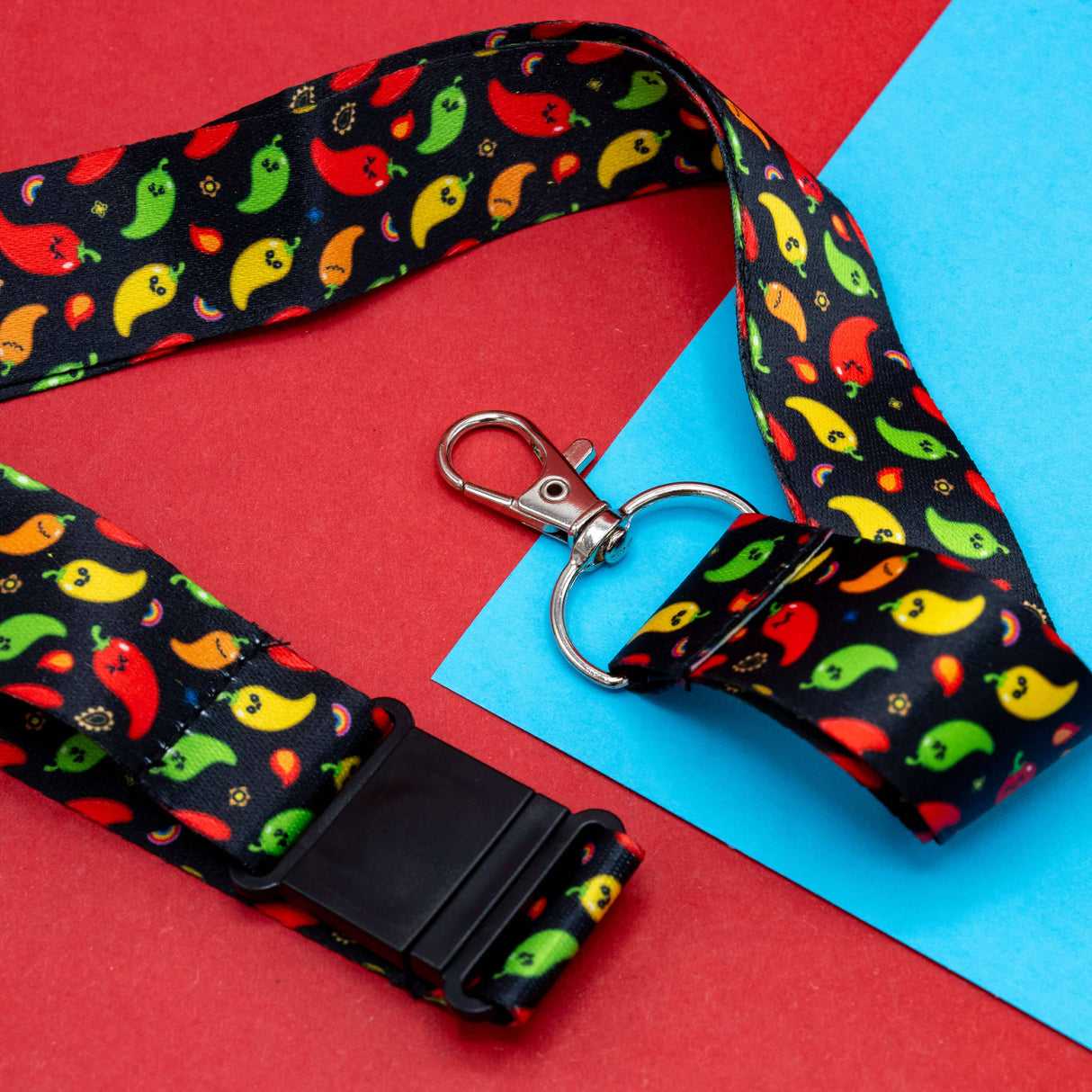 black lanyard with red green yellow orange chili pattern and metal clasp