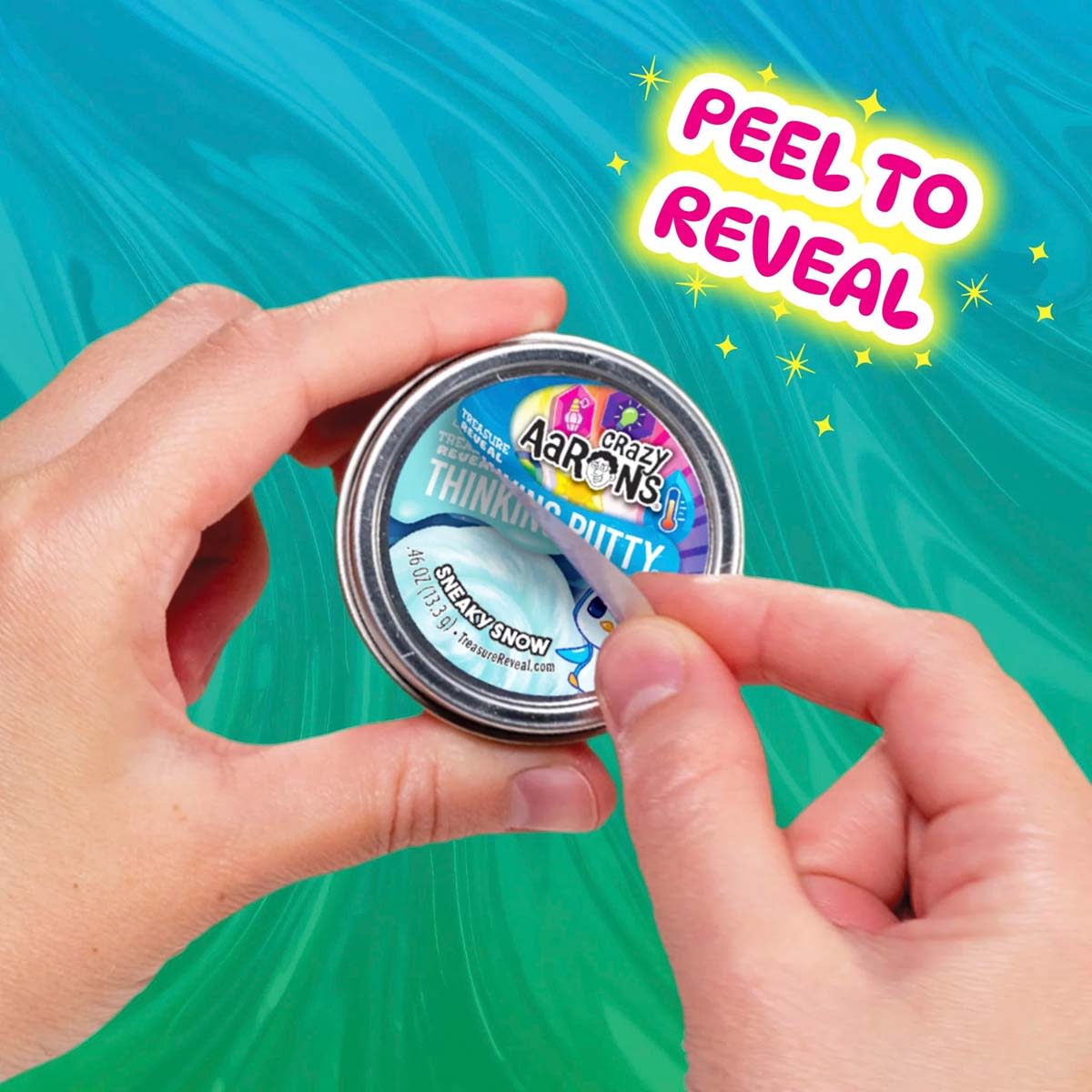 Hands peeling the label off a Crazy Aaron's Treasure Reveal Sneaky Snow putty tin