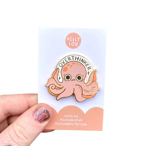 Pin with an octopus design on a card held against a white background