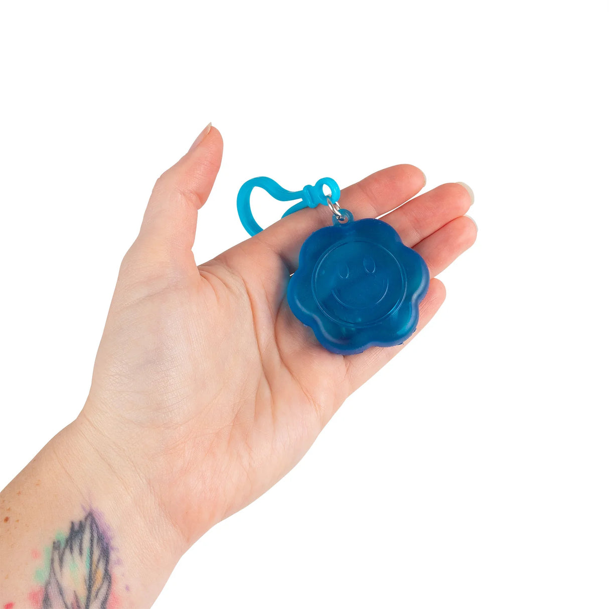 Blue Flower Power squishy keyring resting in a palm showing size reference