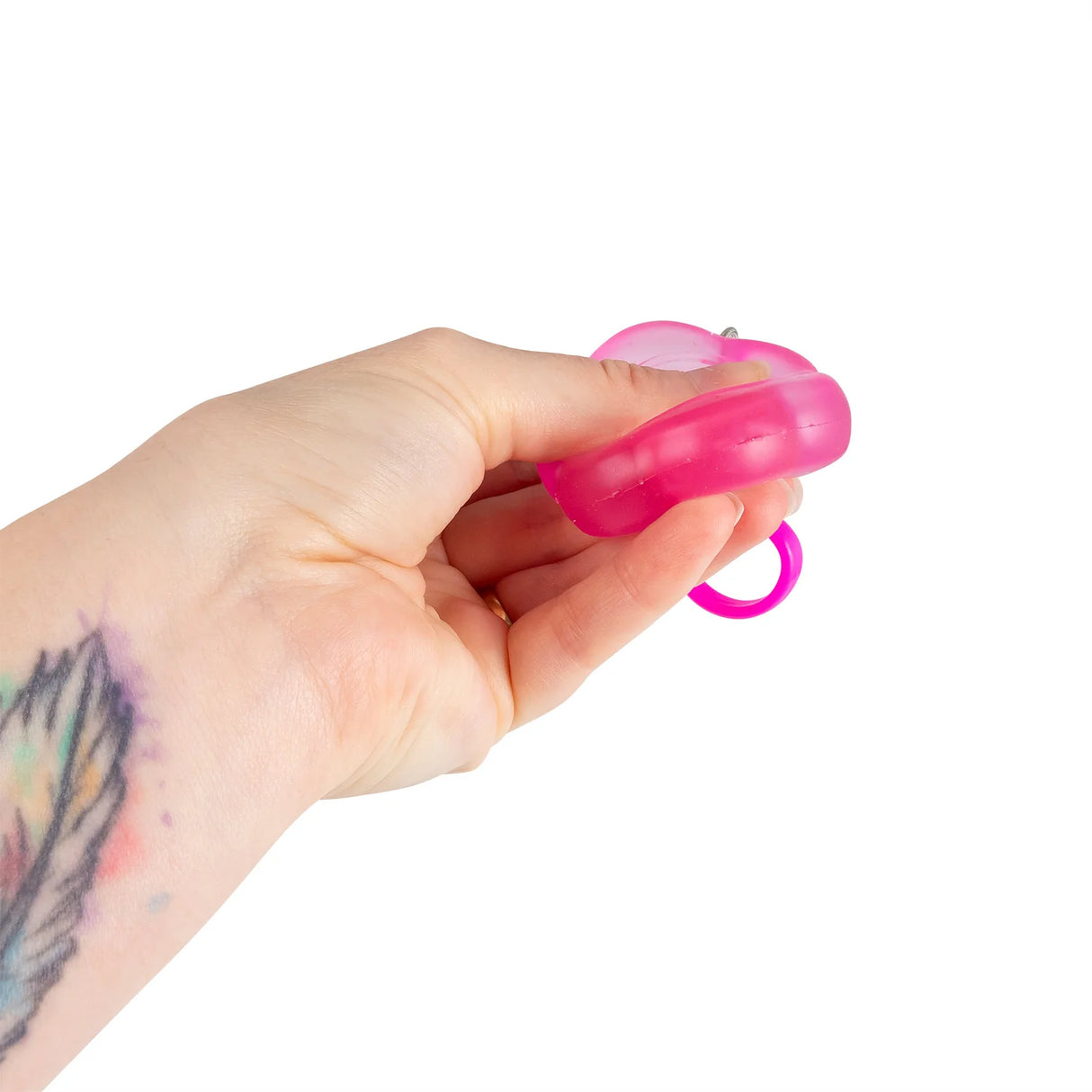 Hot pink Flower Power squishy keyring being squeezed in a hand showing flexibility