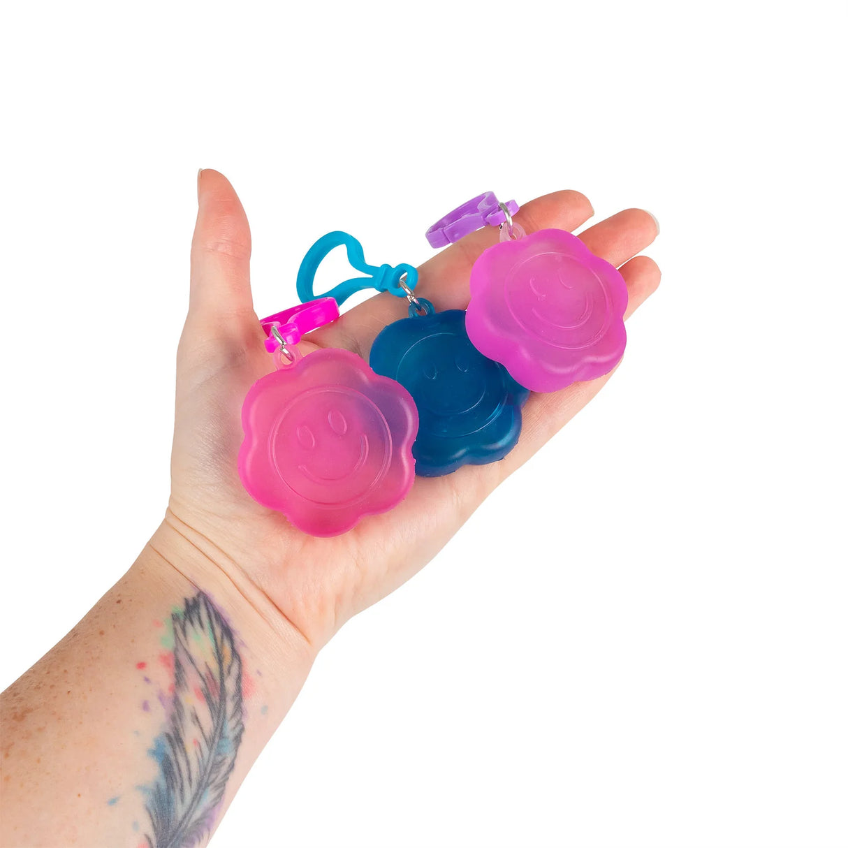 Three Scrunchems Flower Power squishy keyrings in hot pink, blue, and purple displayed together