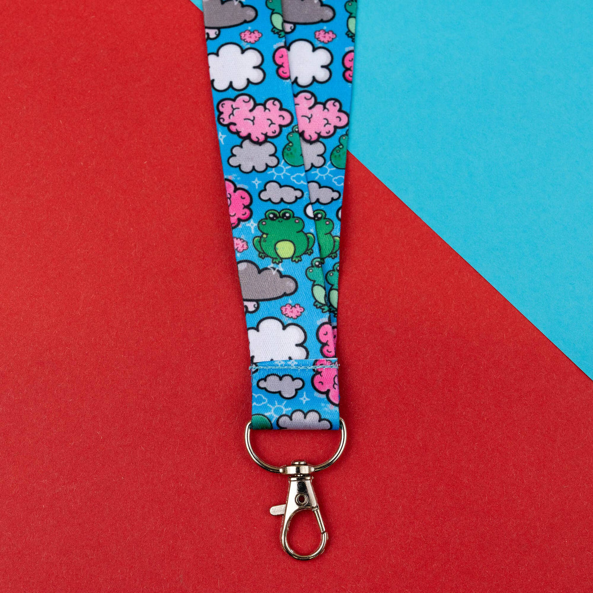bright blue frog and clouds lanyard with silver clasp on red blue background