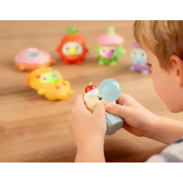Child squeezing a cupcake Gum Gums figure blowing a blue bubble beside other characters