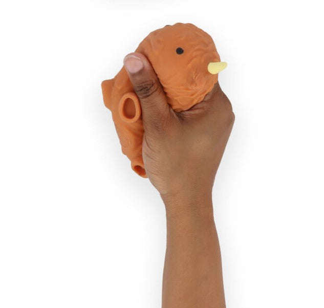 Hand squeezing an orange-brown highland cow stretchy squishy fidget toy