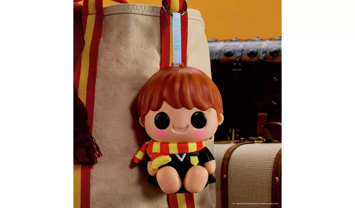 Hyojo Ron squishy collectible keychain with red hair and striped scarf clipped to tote bag