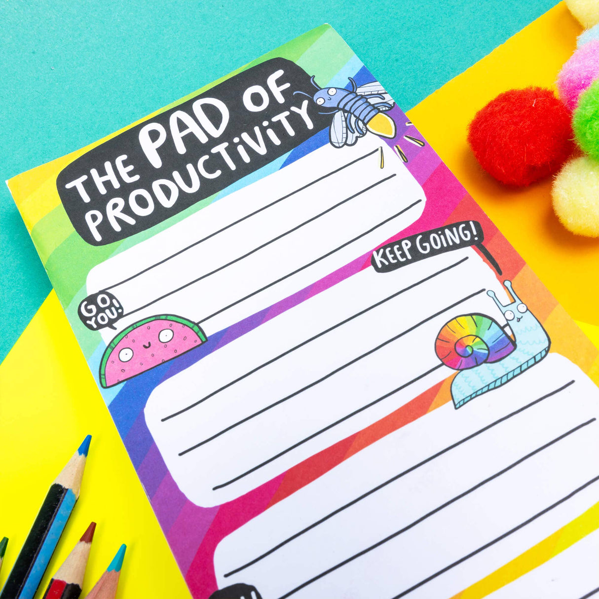 Katie Abey Pad of Productivity rainbow notepad, close-up top half, pencils and pompoms