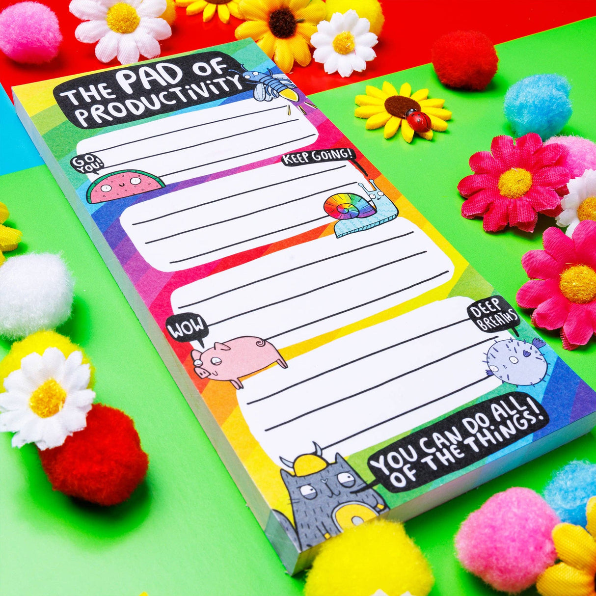 Katie Abey Pad of Productivity rainbow notepad, angled, pompoms and flower props