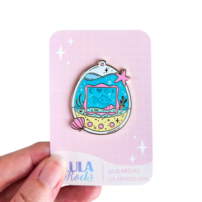 Lula Rocks Digital Aquarium enamel pin on pink Lula Rocks backing card, white background