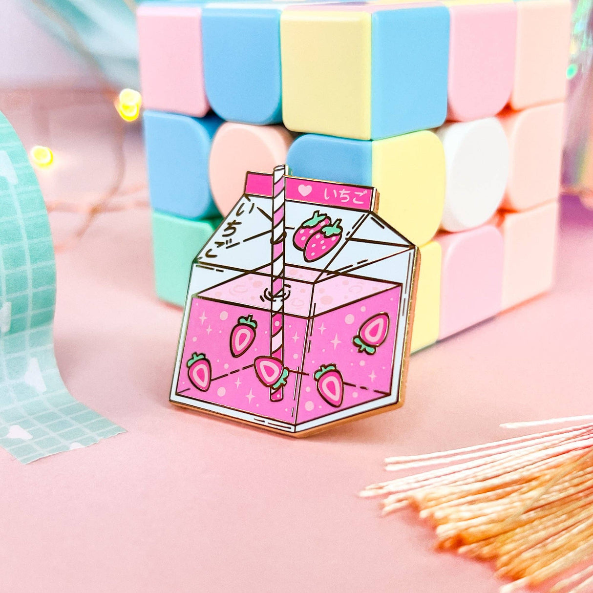 Lula Rocks Strawberry Milk enamel pin, pink, angled view against pastel blocks