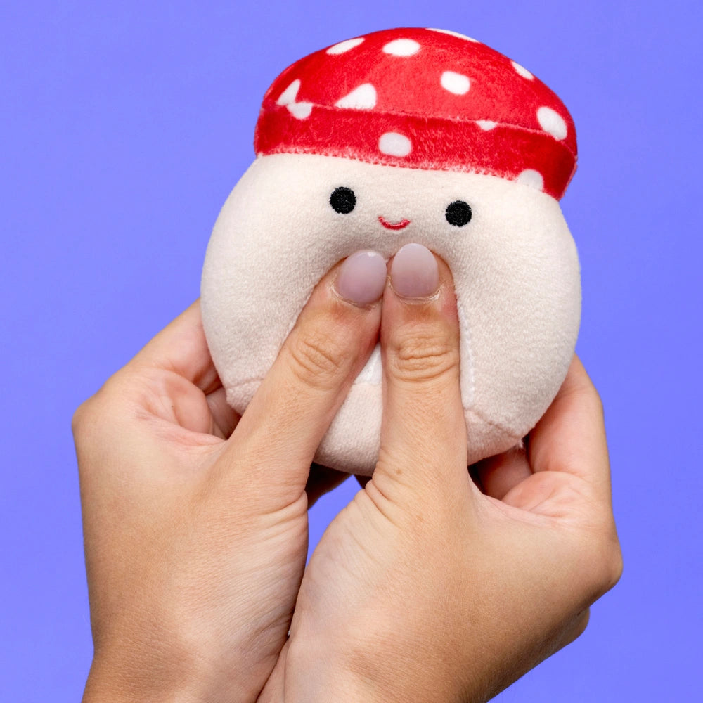 Hand squeezing Malcolm the Mushroom MallowMees by Squishmallows weighted plush