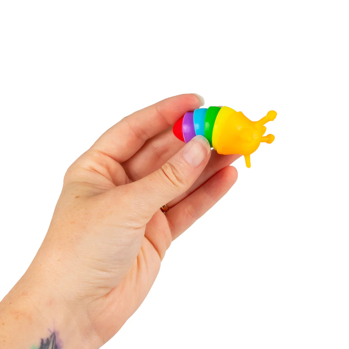 Adult hand holding a rainbow-coloured micro fidget slug with segmented body
