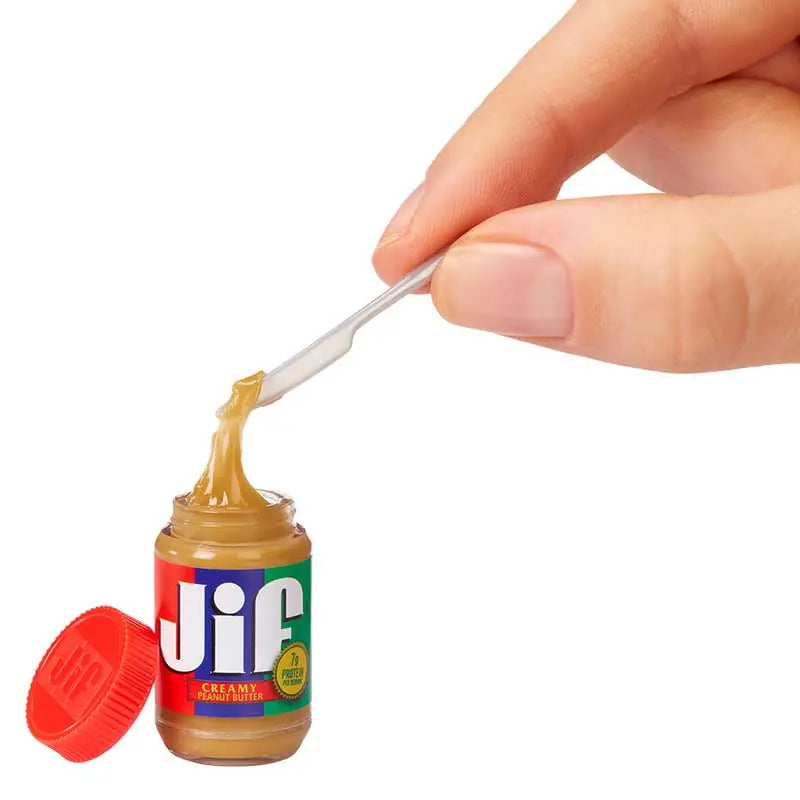 MGA Miniverse Real Brands miniature Jif peanut butter jar with removable lid and tiny spoon, held in fingers to show scale