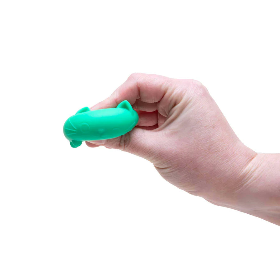 Hand squeezing the teal Whiskers Nee Doh Cool Cat squishy flat