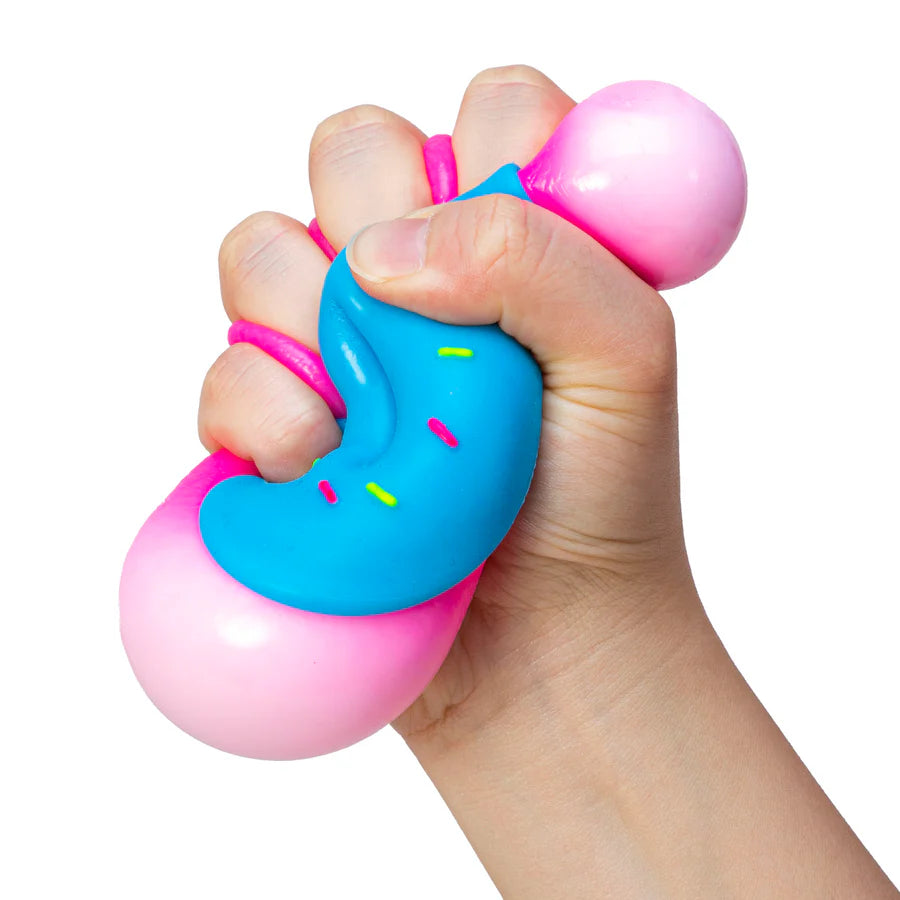Hand squeezing a blue and pink NeeDoh Dohnut squishy toy showing the satisfying squish deformation