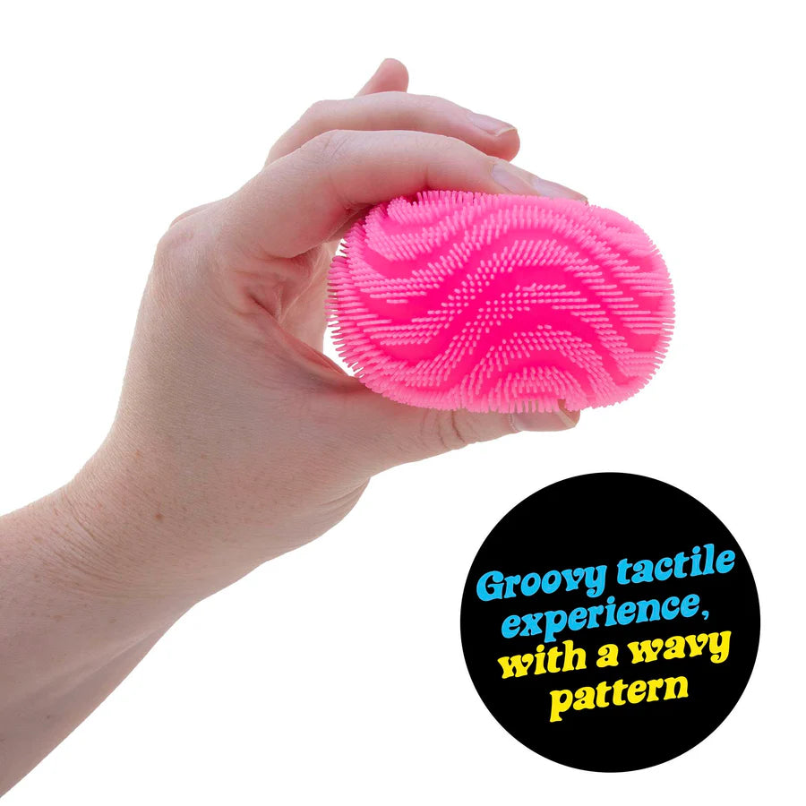 Hand holding pink NeeDoh Fuzz Ball Wonder Waves showing the raised wavy spike texture detail