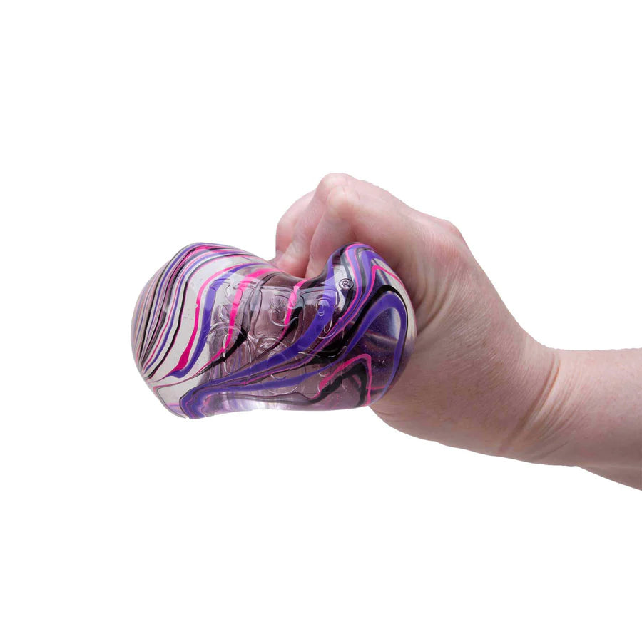 Hand squeezing purple and black marbled Nee Doh Nice Berg Swirl showing satisfying squish deformation
