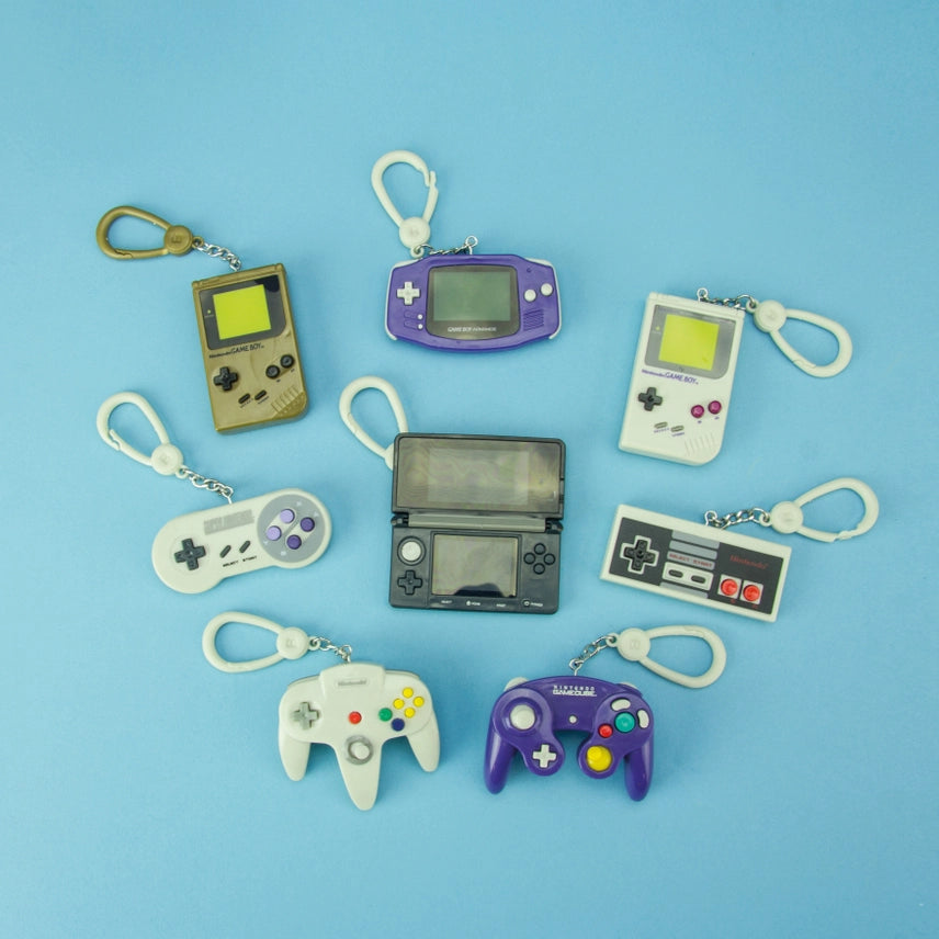 All eight Paladone Nintendo Classic Console backpack buddies keyrings on blue background