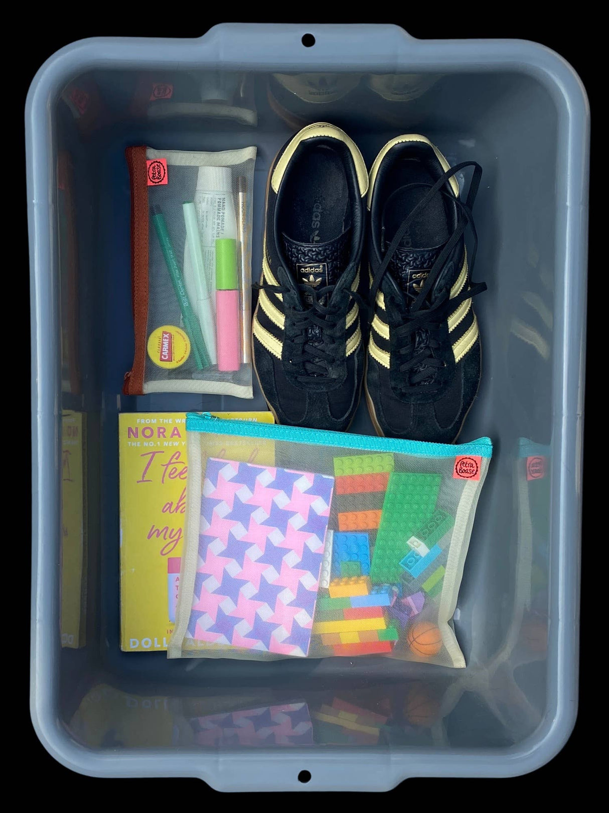 clear storage bin with mesh pouches book adidas trainers and small fidget items
