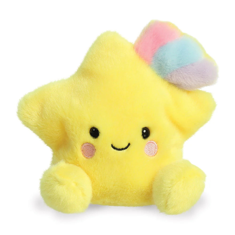 Aurora Palm Pals Pisces Shooting Star plush β a bright yellow star-shaped soft toy with a pastel rainbow tuft of pink, blue, and purple on top, pink blush cheeks, and a cheerful smiling face