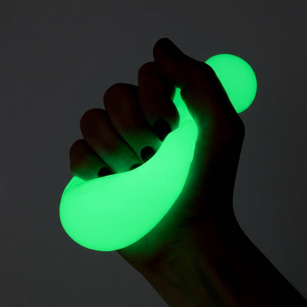 Hand holding a green glowing object against a dark background