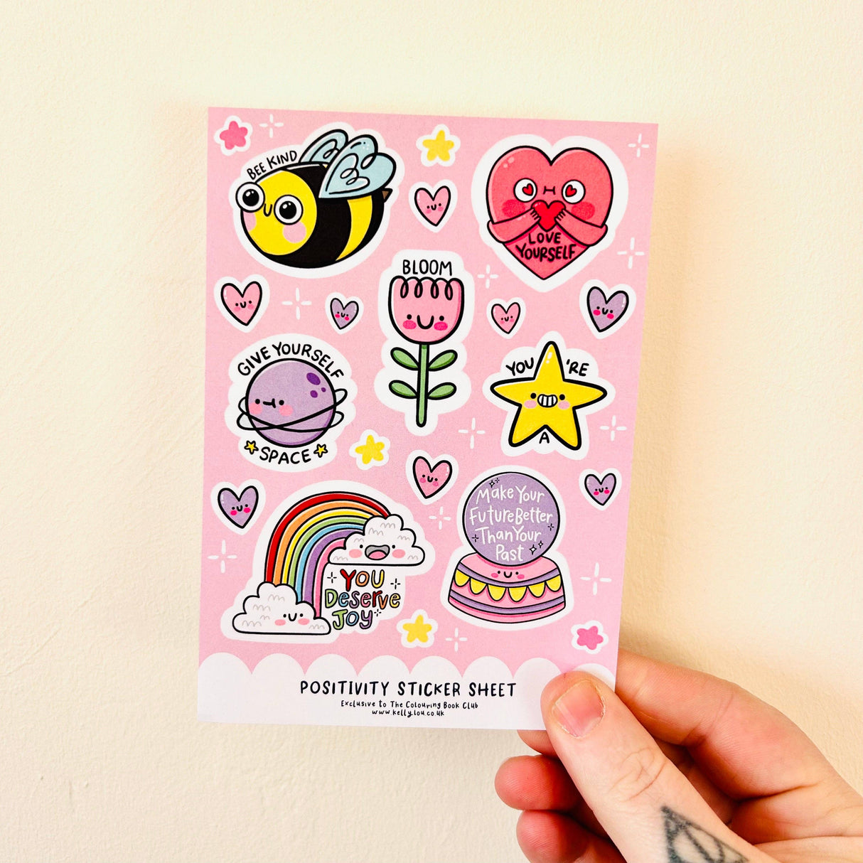 Close-up of the Positivity Sticker Sheet showing kawaii bee, heart, flower, planet, star, rainbow and crystal ball stickers with affirmation messages