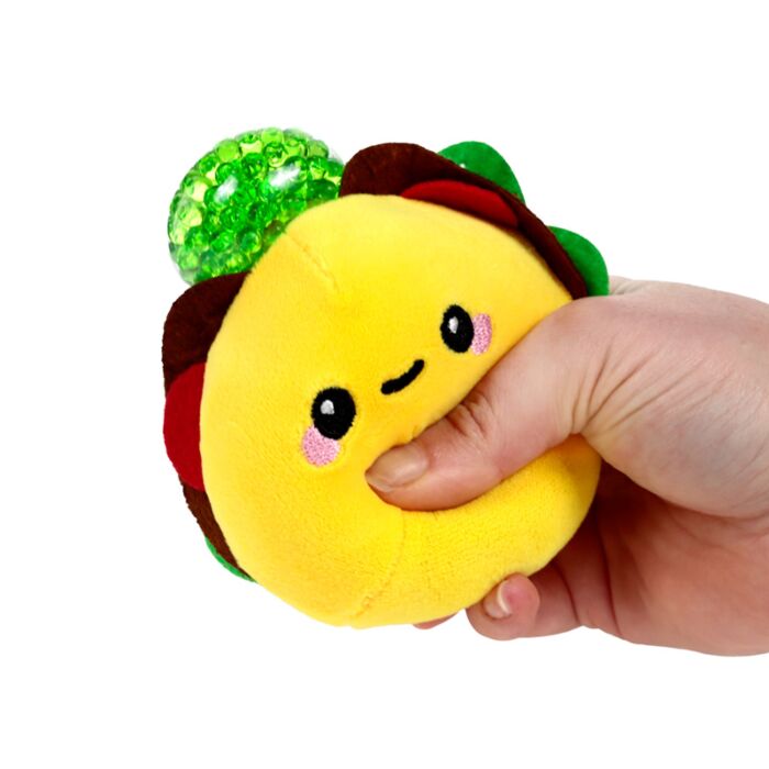 Hand squeezing a plush burger Queasy Squeezie causing yellow water bead top to bulge out