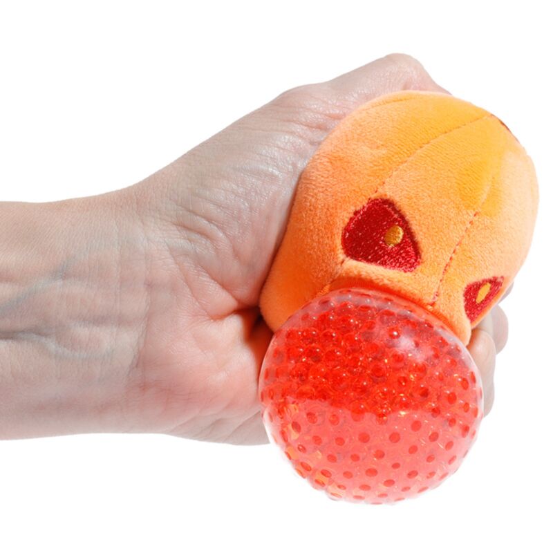 Hand squeezing the red gel bead centre of a Queasy Squeezies pumpkin plush toy