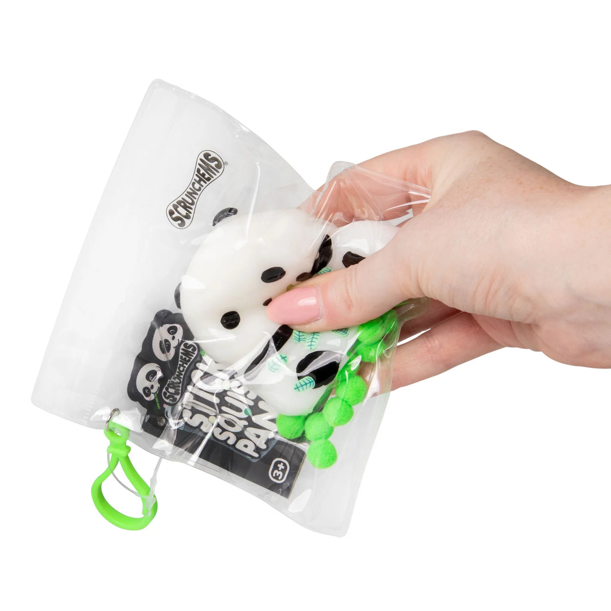 Hand squeezing a white and black Scrunchems Sticky Squishy Panda through its resealable packaging bag