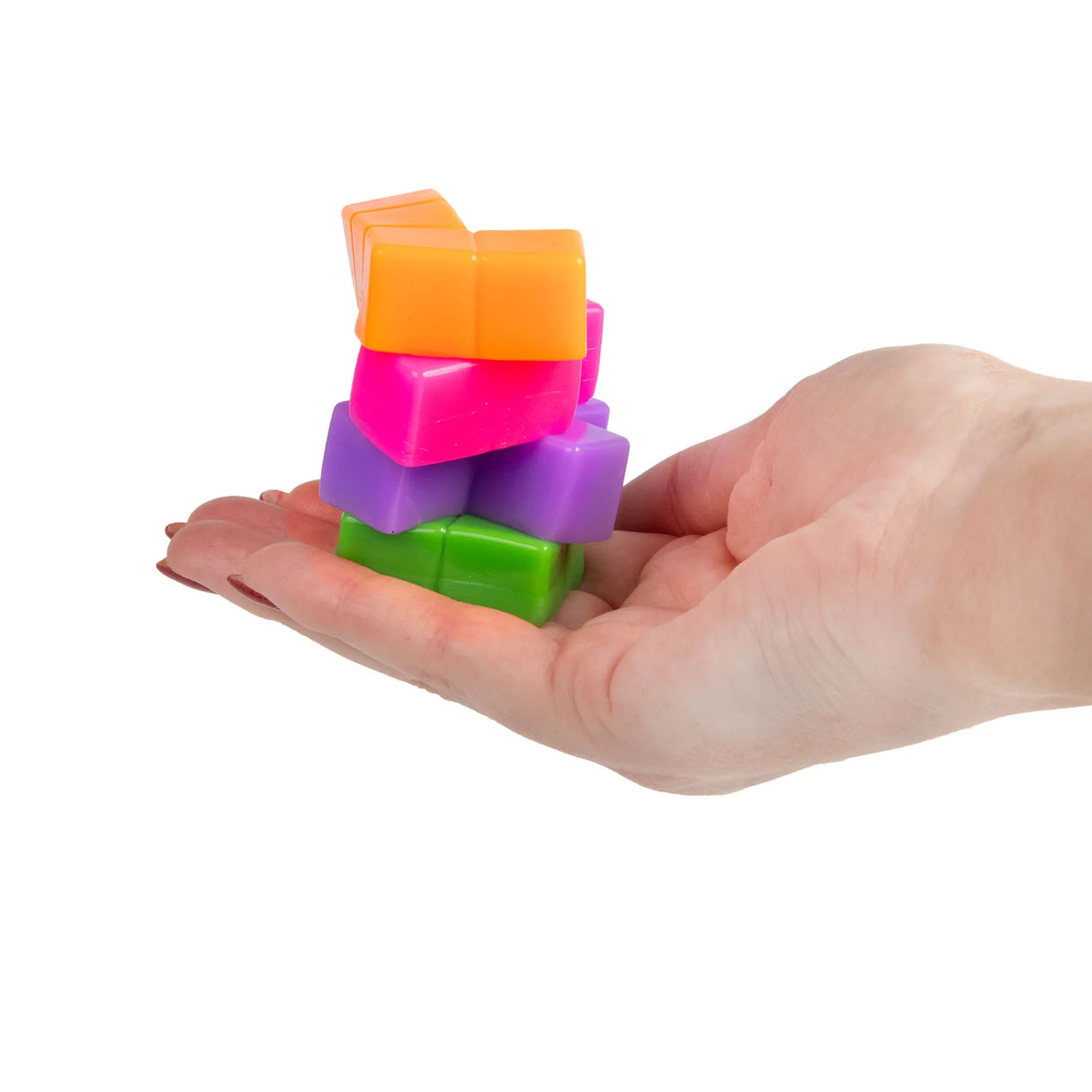 Four neon squishy tetromino puzzle pieces stacked on an open palm in orange, pink, purple and green