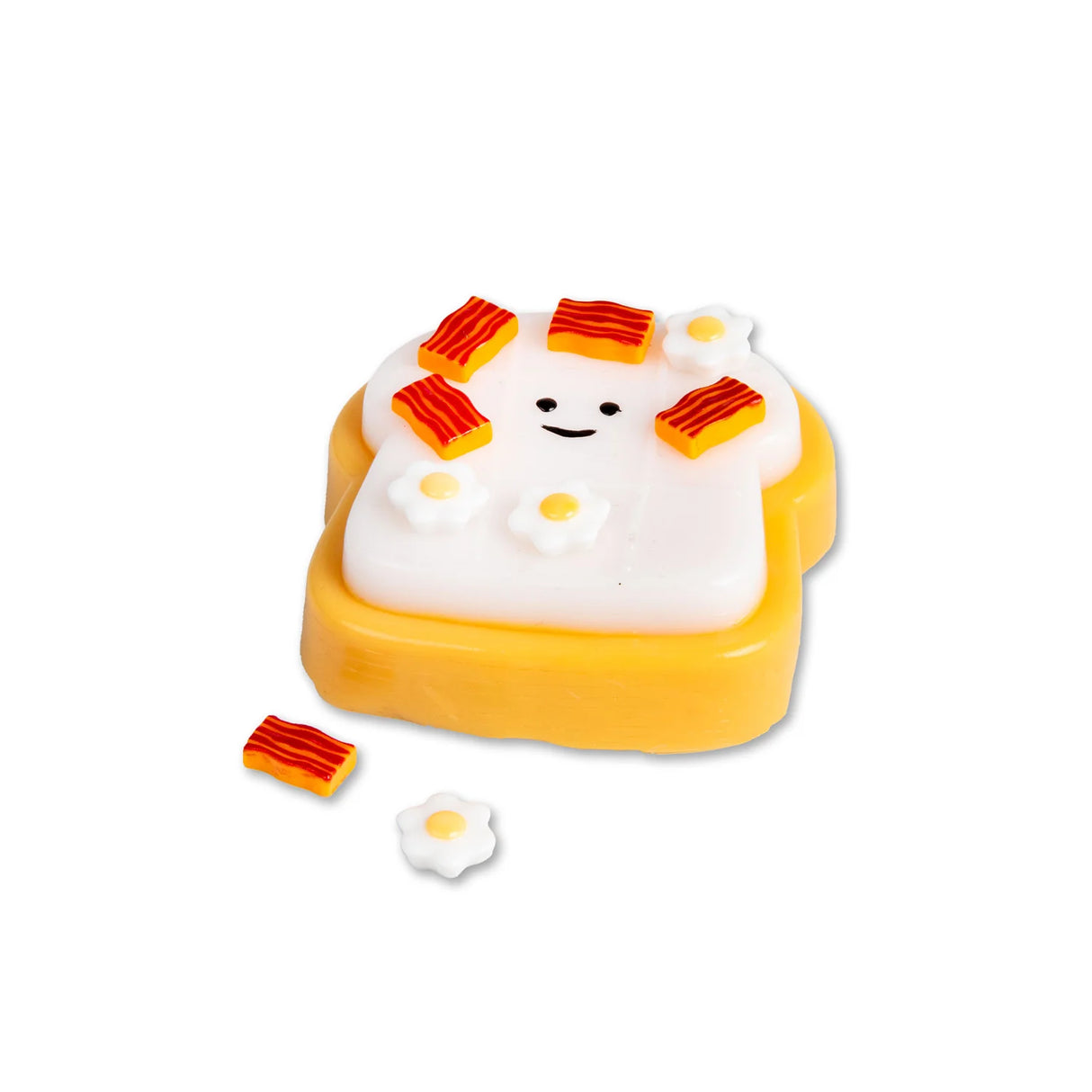 Smiling Scrunchems toast squishy covered in sticky bacon and fried egg pieces with loose accessories beside it