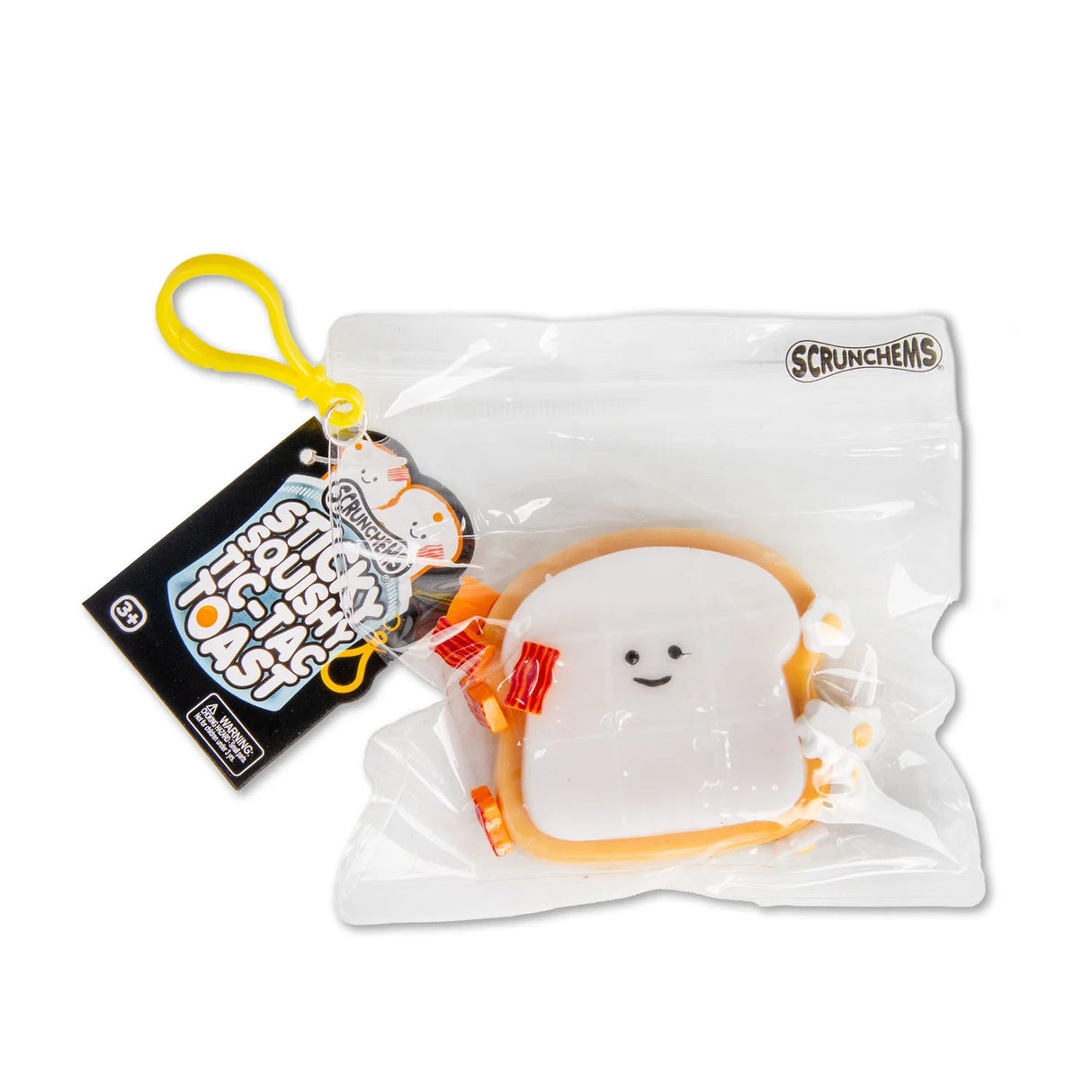 Scrunchems Sticky Squishy Tic-Tac Toast in resealable bag with branded tag, yellow clip hanger, and bacon and egg accessories visible
