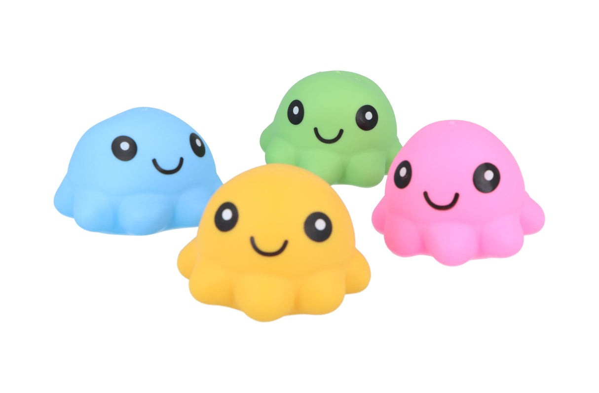 Four kawaii-style squishy octopus squeeze toys in blue, yellow, green, and pink, each with a smiling face, arranged in a loose cluster against a white background