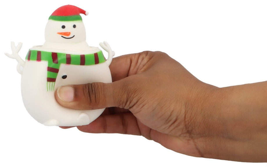 Hand squeezing pop-up snowman squishy toy with red santa hat and green scarf