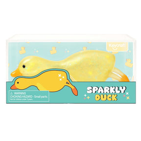 Yellow glitter squishy duck toy shown in clear Keycraft branded packaging with duck-print background