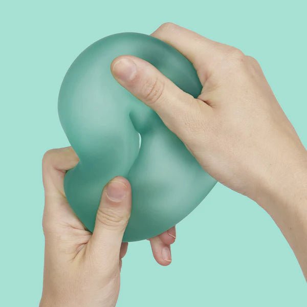 Two hands squeezing and deforming mint green Speks Gump Jumbo Loop fidget toy