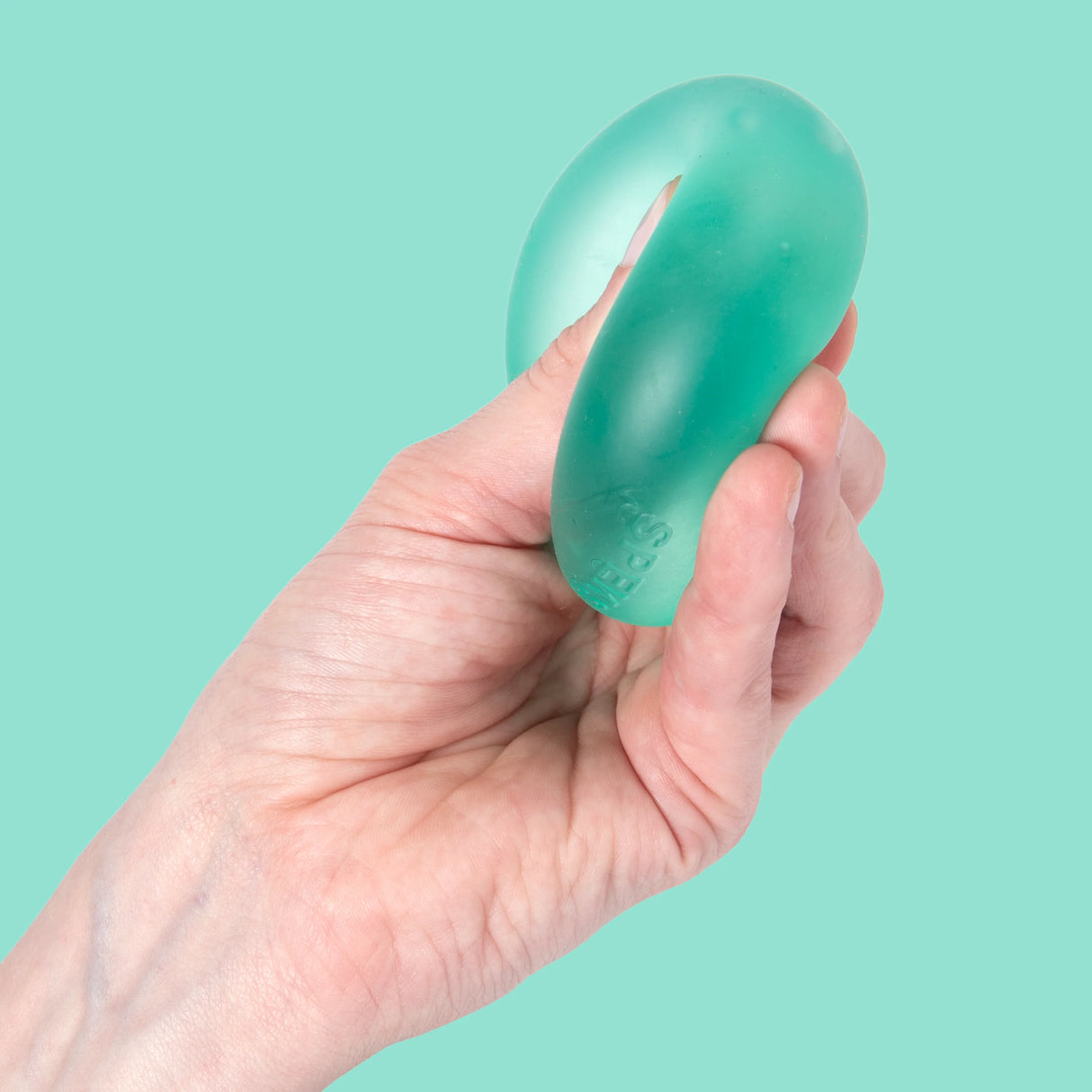 Hand stretching a teal Sea Glass Speks Gump Original memory gel stress ball showing its full pliable length