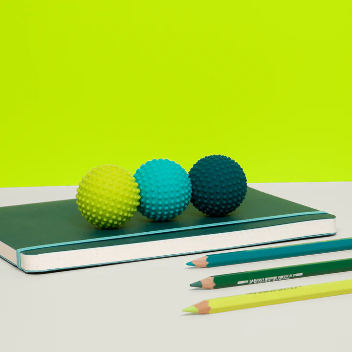 Speks Odds Green Dots sensory fidget magnets on notebook, desk toy