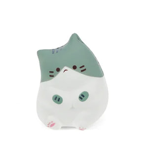 Front view of a green and white kawaii sitting cat squishy toy with pink paws and stripe markings