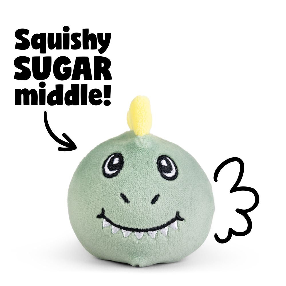 Green squishy dinosaur plush sensory toy with yellow horn and embroidered smile showing squishy sugar-filled middle