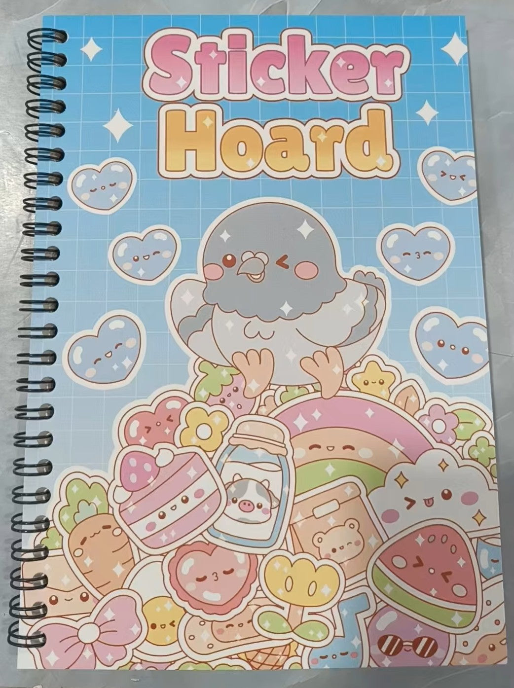 Kawaii Sticker Hoard spiral book with pigeon and kawaii sweet treats cover design on blue background