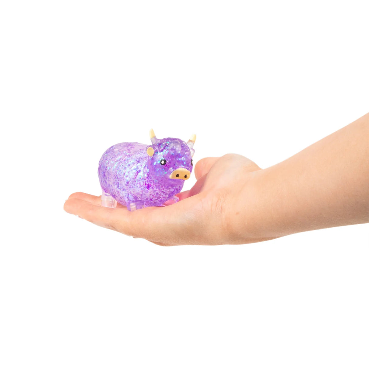 Purple glitter Sugar Highland Cow squishy being held in an open palm to show size