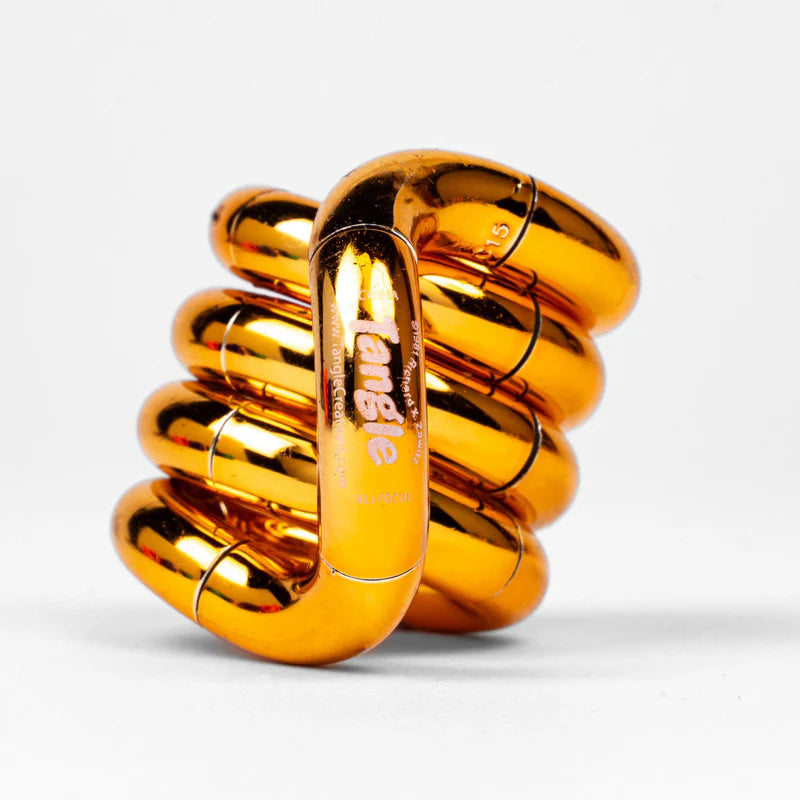 Gold and orange metallic Tangle Jr. fidget toy coiled into its resting spiral shape showing chrome finish