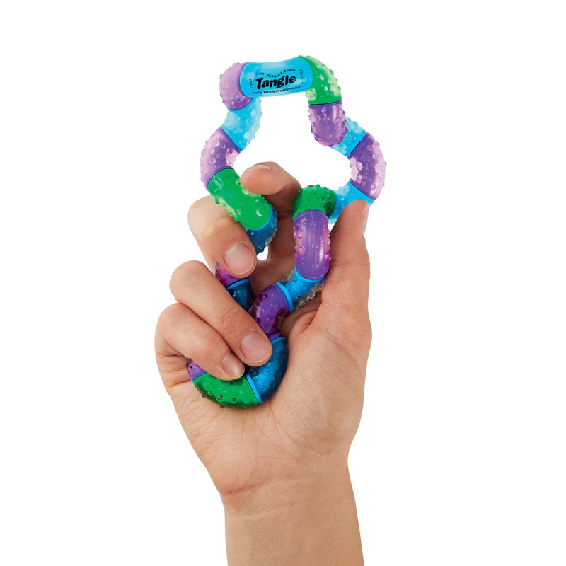 Colorful Tangle toy held in a hand on a white background
