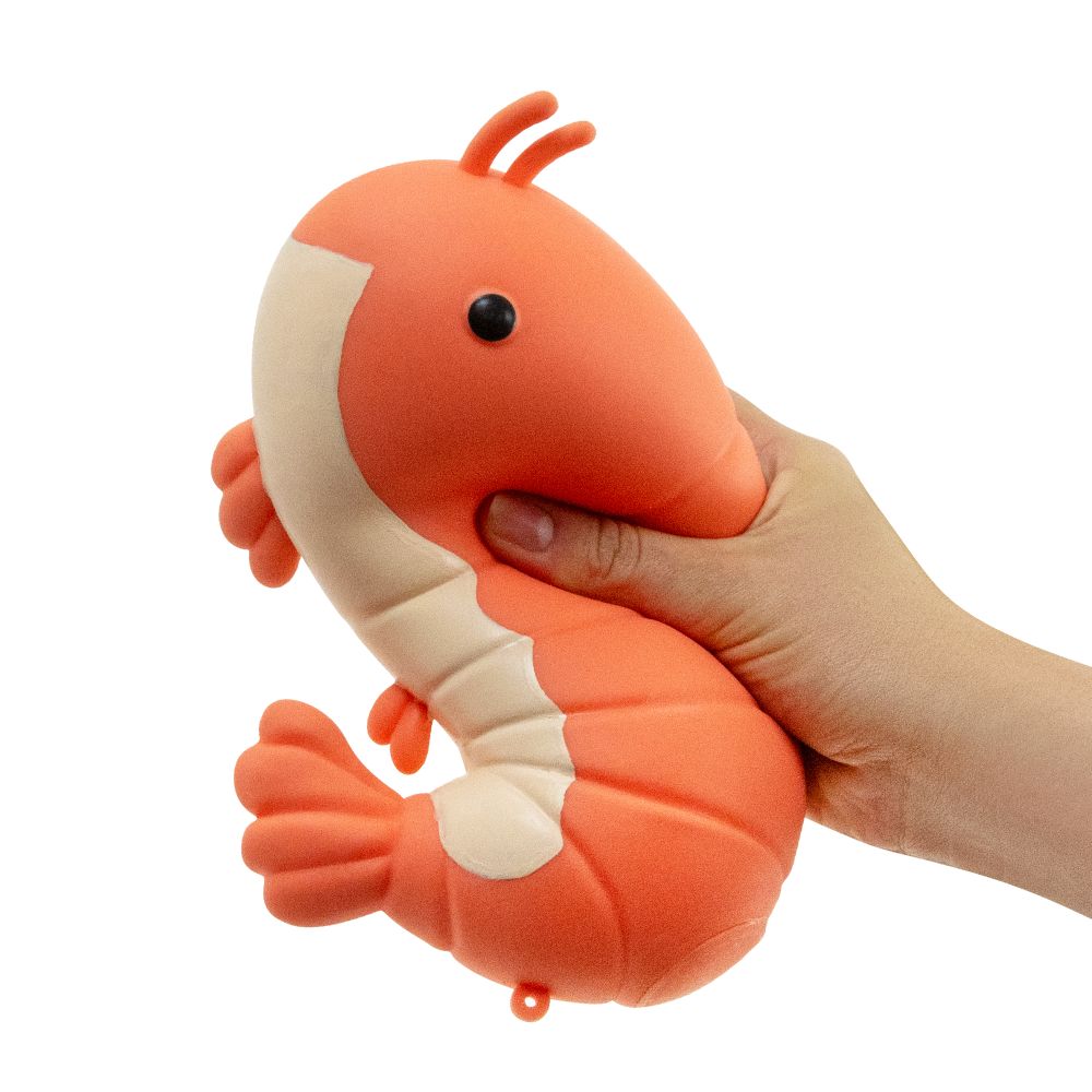Hand squeezing The Big Squij giant shrimp slow rise squishy in coral and cream