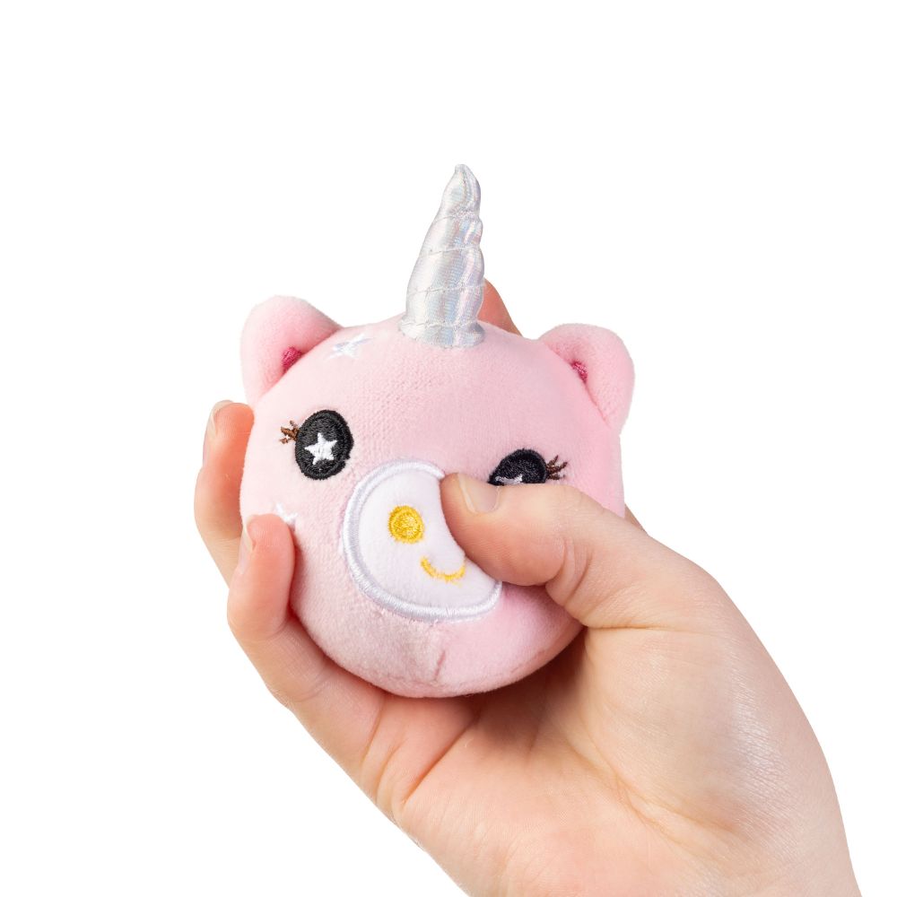 Hand squeezing a pink unicorn plushie sensory toy to show size and squishy texture