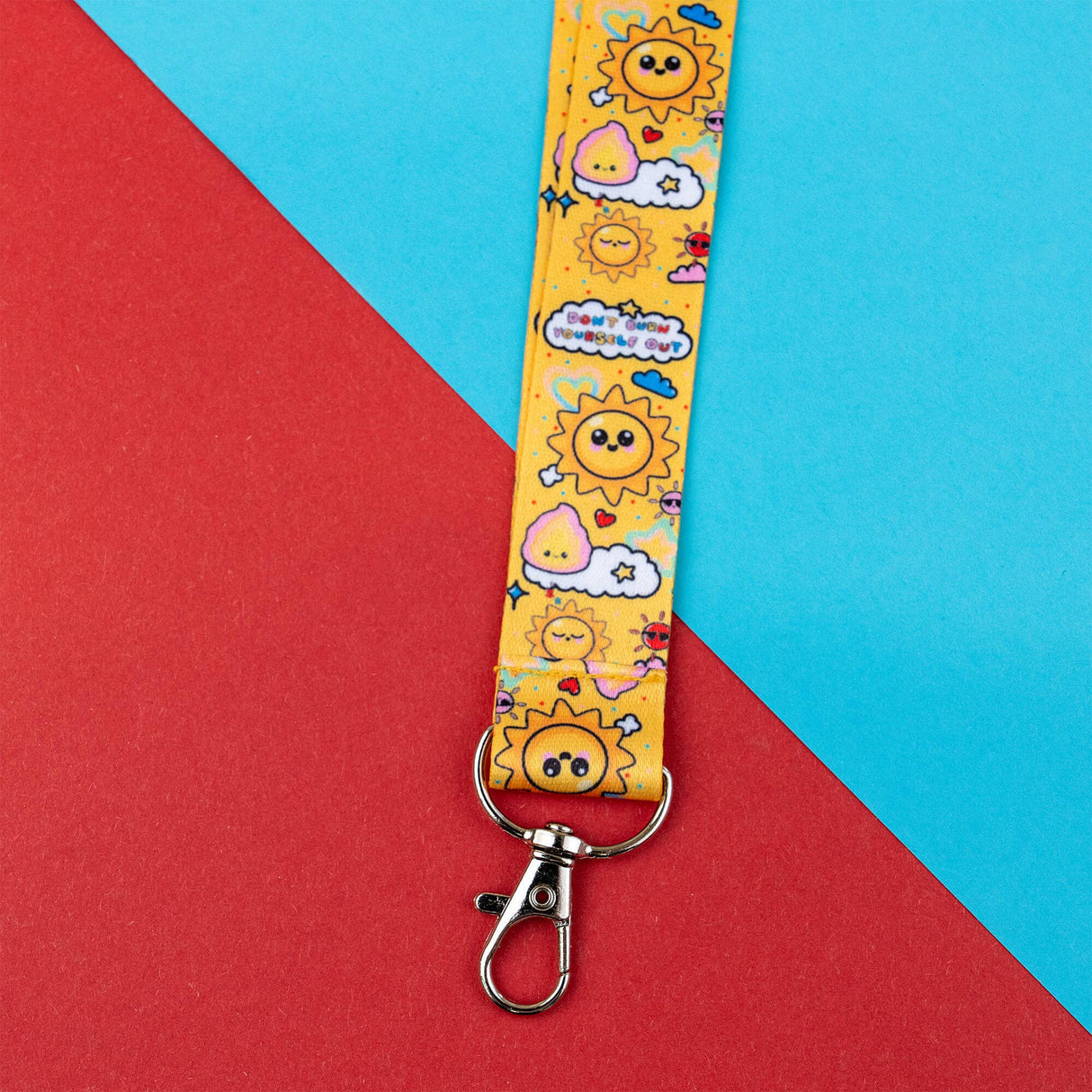 Yellow lanyard with cartoon sun design on a red and blue background